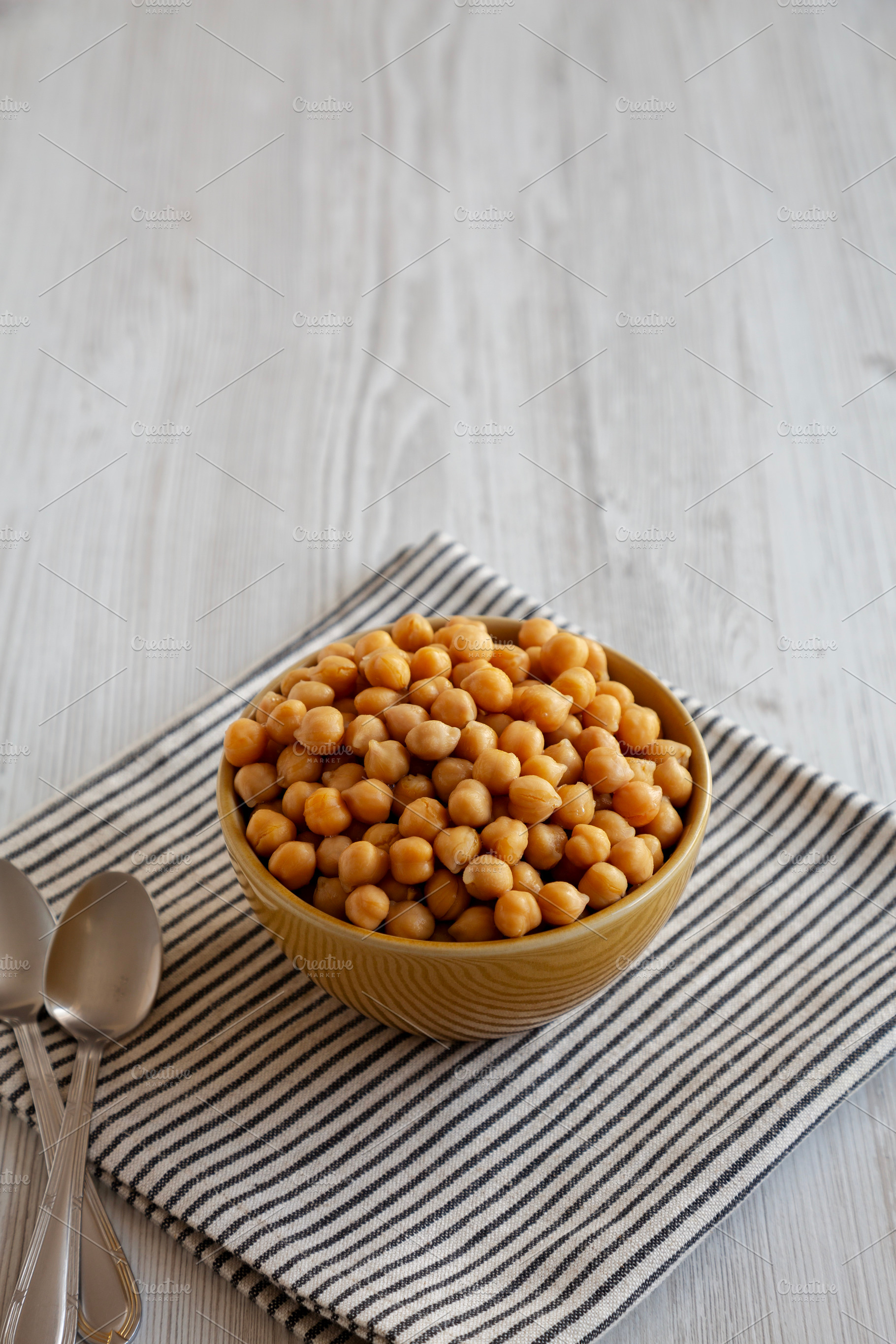 Organic Raw Canned Chickpeas in a Bowl, side view. Space for tex, a Food & Drink Photo by LiudmylaChuhunova