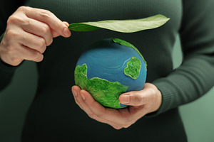 Hands holding globe with green leaf symbolizing environmental pr, a Photo by salmon.black