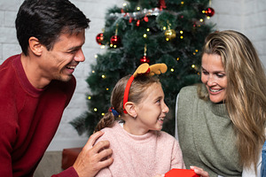 Happy family laughing together during Christmas celebration, a Holiday Photo by etorres69