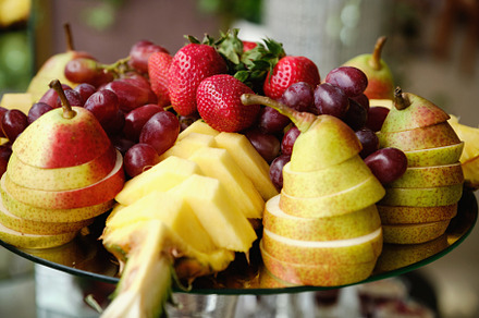 Elegant Fruit Platter with Strawberries, Grapes, Sliced Pears, and Pineapple.