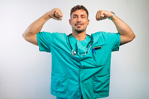 Smiling Doctor Flexing His Arm Muscles, a Person Photo by karrastock