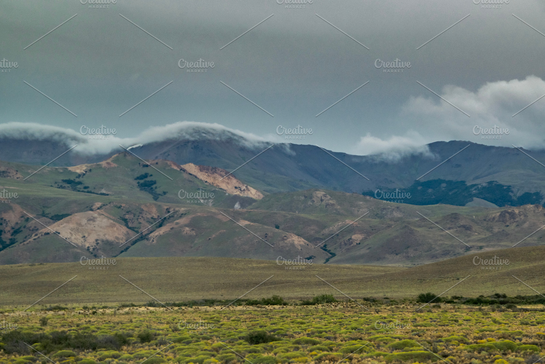 Mountains covered by big clouds at top, chubut province, argenti, a Photo by DanFLCreativo