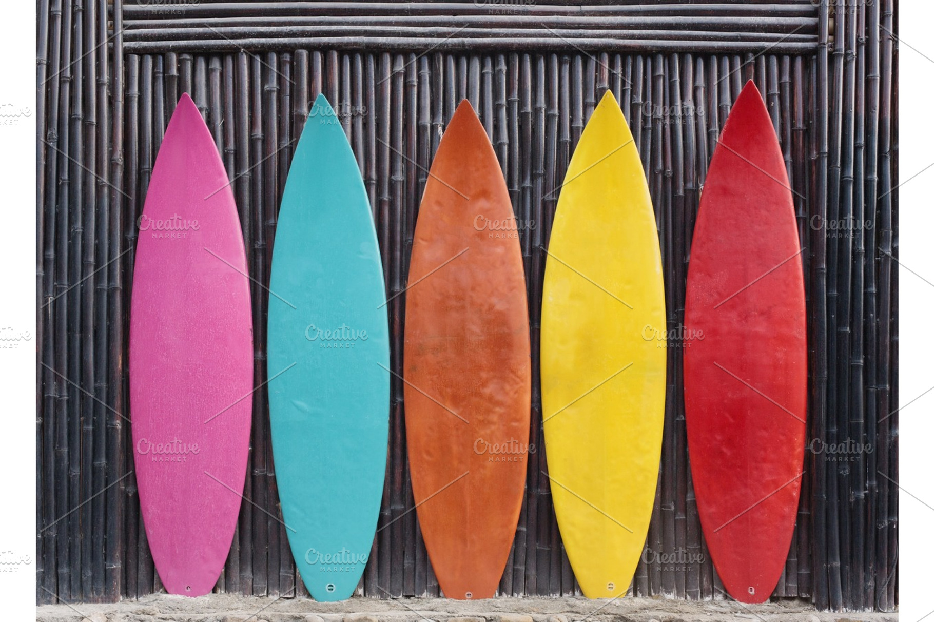 Colored surfboards leaning up against a wooden fence featuring surfboard, a Holiday Photo by Jyliana's shop