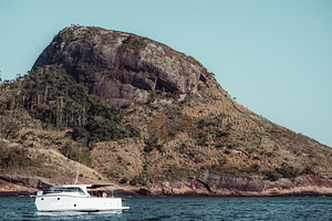 Yacht by rocky island, telephoto, a Sports & Recreation Photo by SkyNext