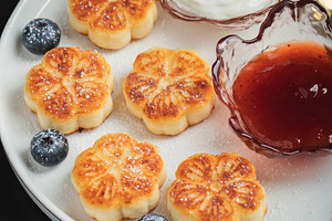 Cottage cheese pancakes, syrniki, curd fritters decorated with strawberry and r, a Food & Drink Photo by Budarinphoto