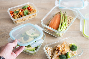 Hand closing glass meal prep containers with healthy homemade food, a Food & Drink Photo by etorres69