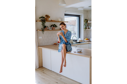 Young woman enjoying cup of coffee, a Person Photo by HalfPoint
