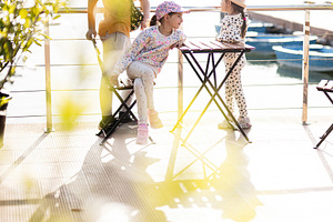 Children laughing and playing outdoors by a lake under sunny skies, a Person Photo by AS photostudio