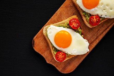 Homemade Healthy Egg, Avocado and Tomato Toast on a rustic woode, a Food & Drink Photo by LiudmylaChuhunova
