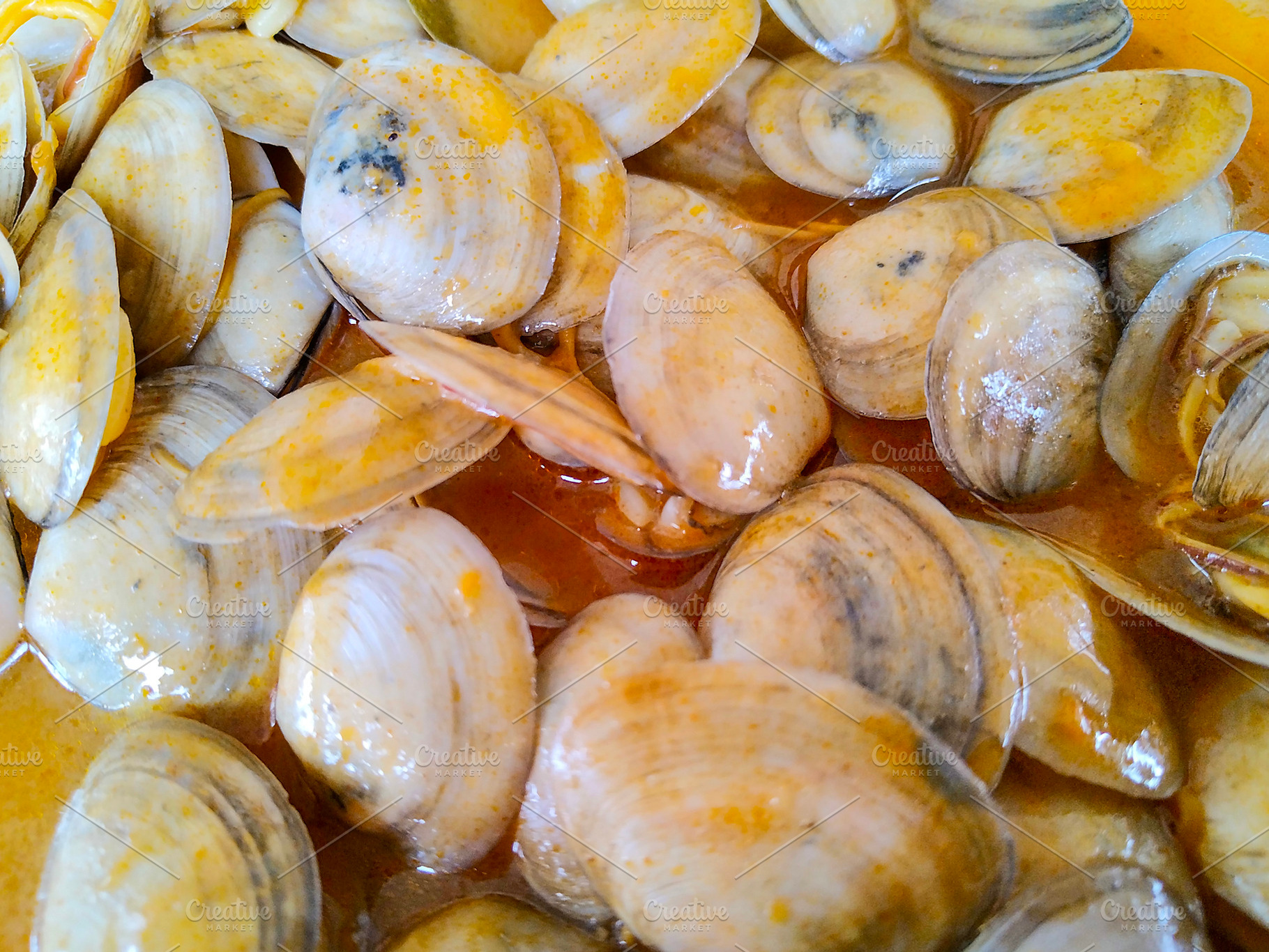 Close-up of clams in warm seafood broth, a Food & Drink Photo by DanFLCreativo