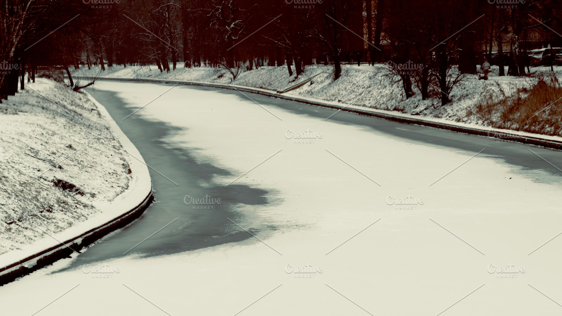 A serene winter scene featuring a snow-covered riverbank, with a winding river, an Industrial Photo by Textures & Backgrounds