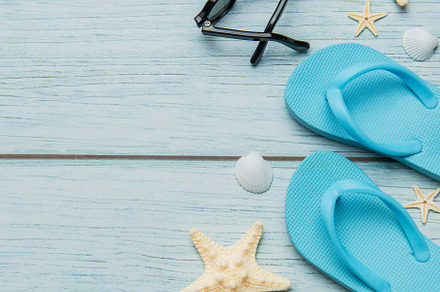 Beach vacation accessories arranged on rustic blue wooden backgr