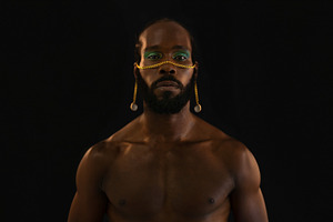 Serious African American shirtless gay model with makeup over black background, a Person Photo by andreonegin market