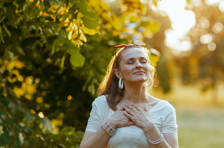 smiling elegant woman in white shirt with hand on chest, a Person Photo by Alliance Images