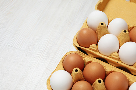 Egg boxes with eggs, space for text, a Food & Drink Photo by AtlasStudio PRO