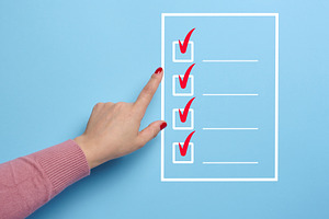 A hand points to a white outline list with red checkmarks and a, a Business Photo by ndanko