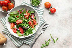 Fresh green salad with tomatoes and arugula, a Food & Drink Photo by Olena Rudo
