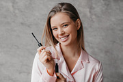 Lovely young lady holding mascara and smiling at camera, applying makeup after, a Photo by Prostock-Studio (Thumbnail 4 of 4)