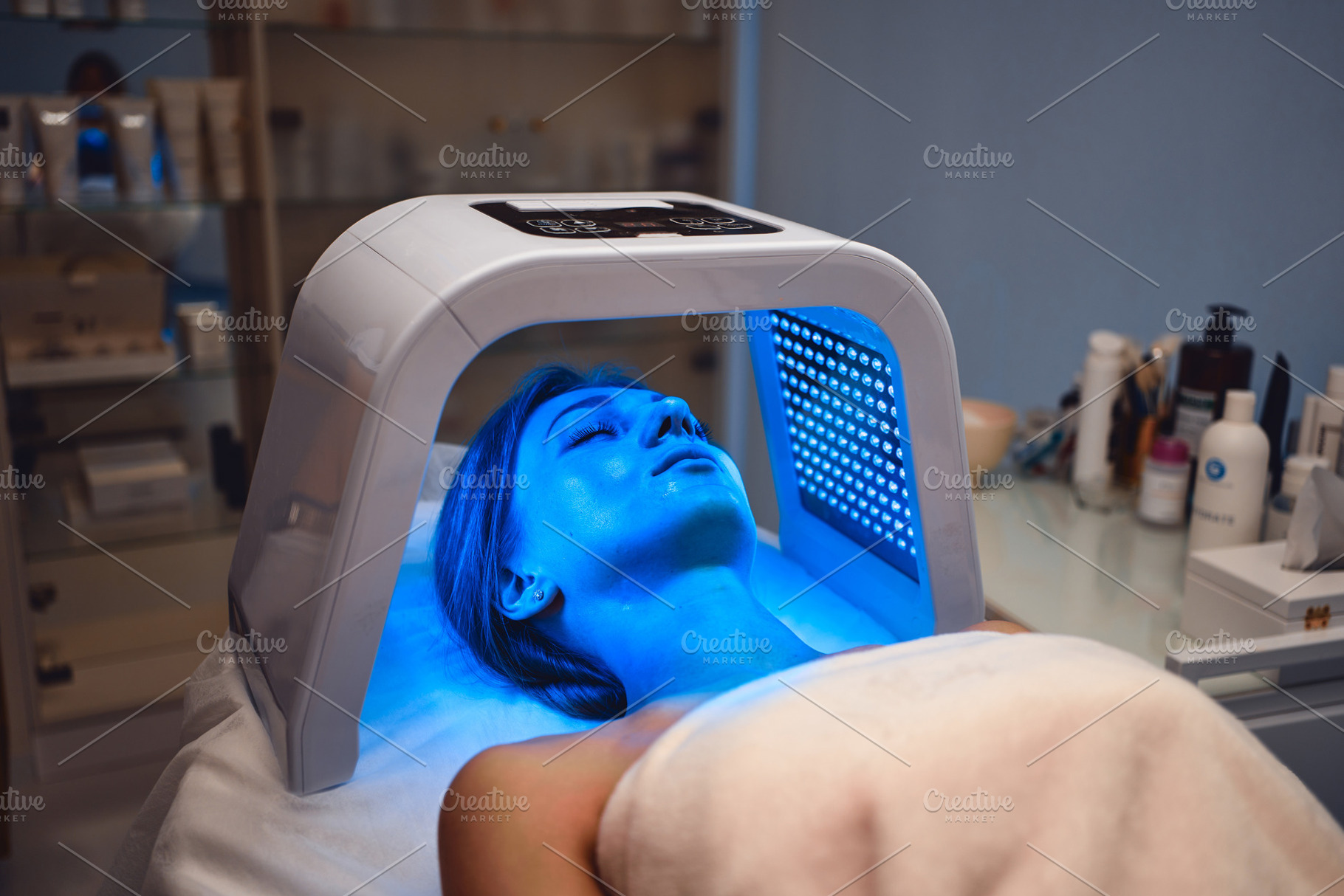 A young woman takes care of her skin with an LED mask in a beauty salon., a Beauty & Fashion Photo by Rov.7