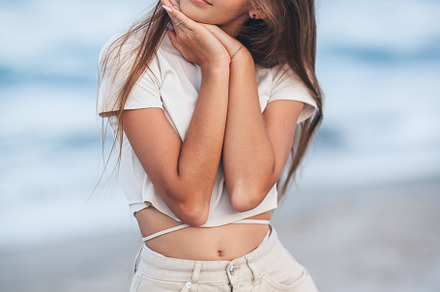 Adorable young girl with beautiful long hair enjoy tropical beach vacation. The, a Person Photo by travnikovstudio