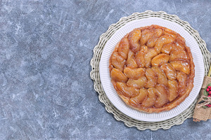 Delicious tarte tatin with caramelized apples, festive table setting, horizonta, a Food & Drink Photo by iuliia_n