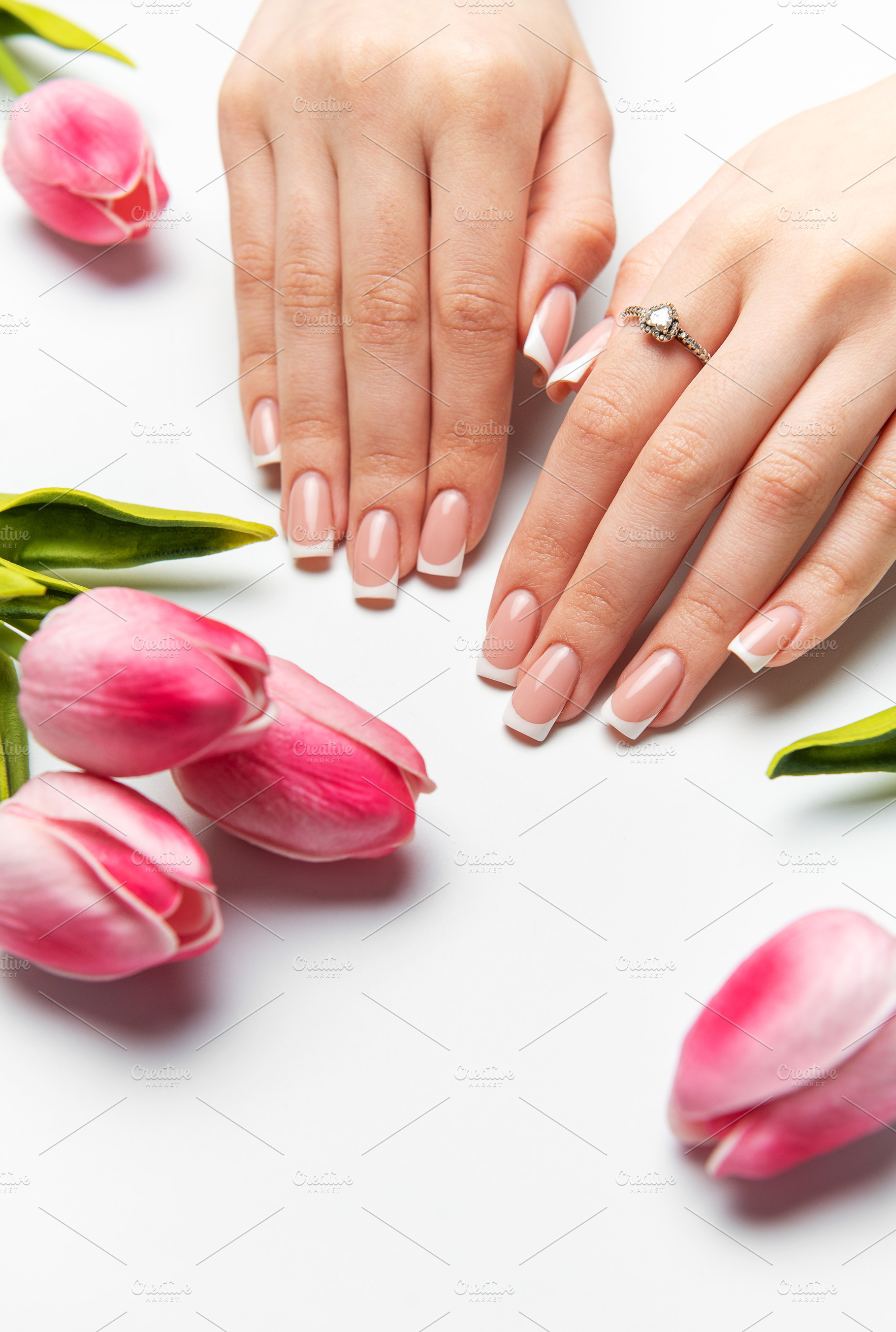 Woman showing french manicure near pink tulips on white backgrou, a Beauty & Fashion Photo by Olena Rudo