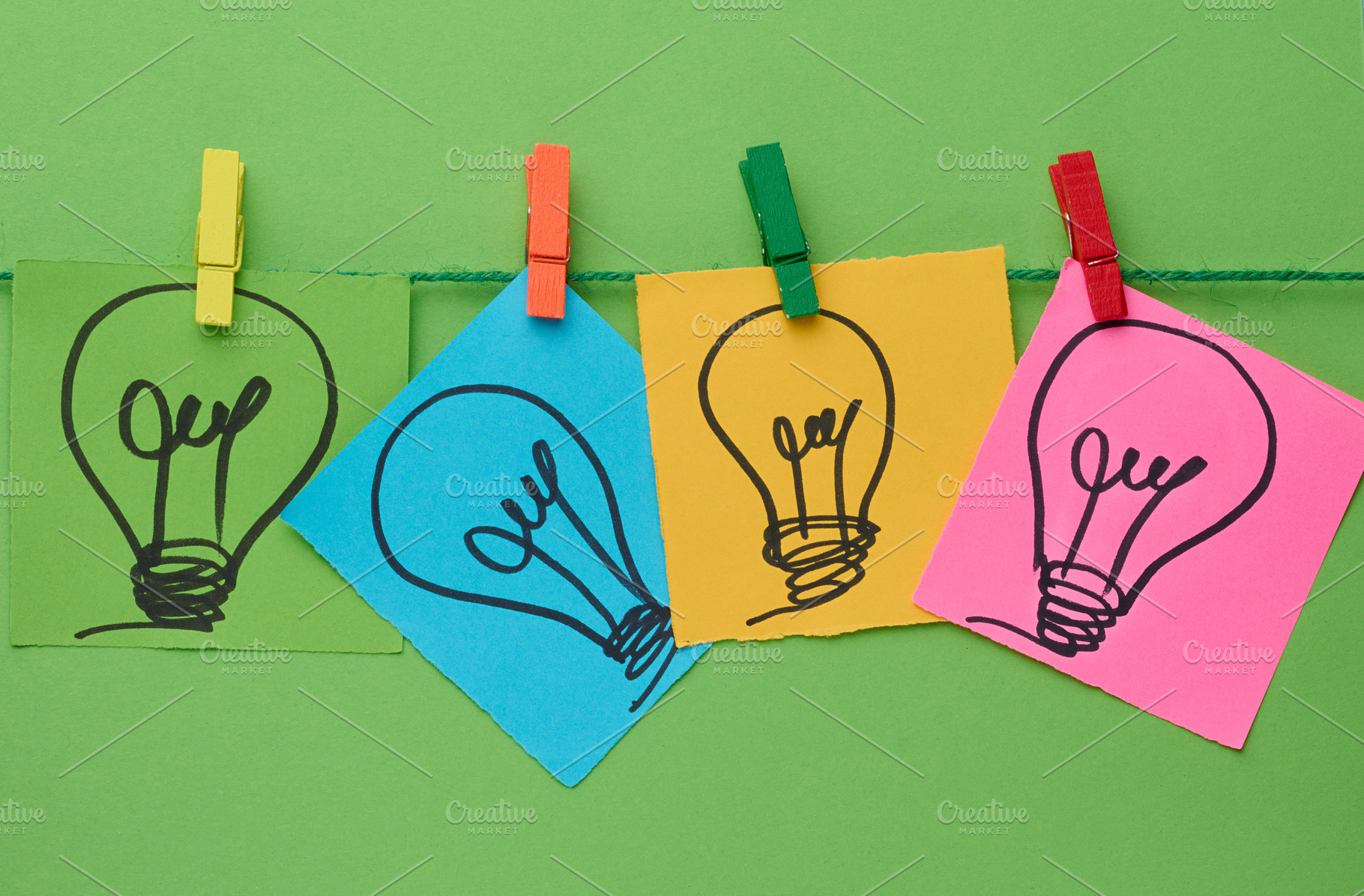 Multicolored stickers with pictures of light bulbs are fastened, a Business Photo by ndanko