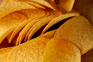 Bacon flavoured potato chips on a wooden board, top view. Close-, a Food & Drink Photo by LiudmylaChuhunova
