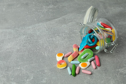Jar with gummy candies on gray textured background, a Food & Drink Photo by AtlasStudio PRO