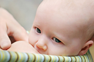 Mother breast feeding her newborn baby, a Photo by saiko3p