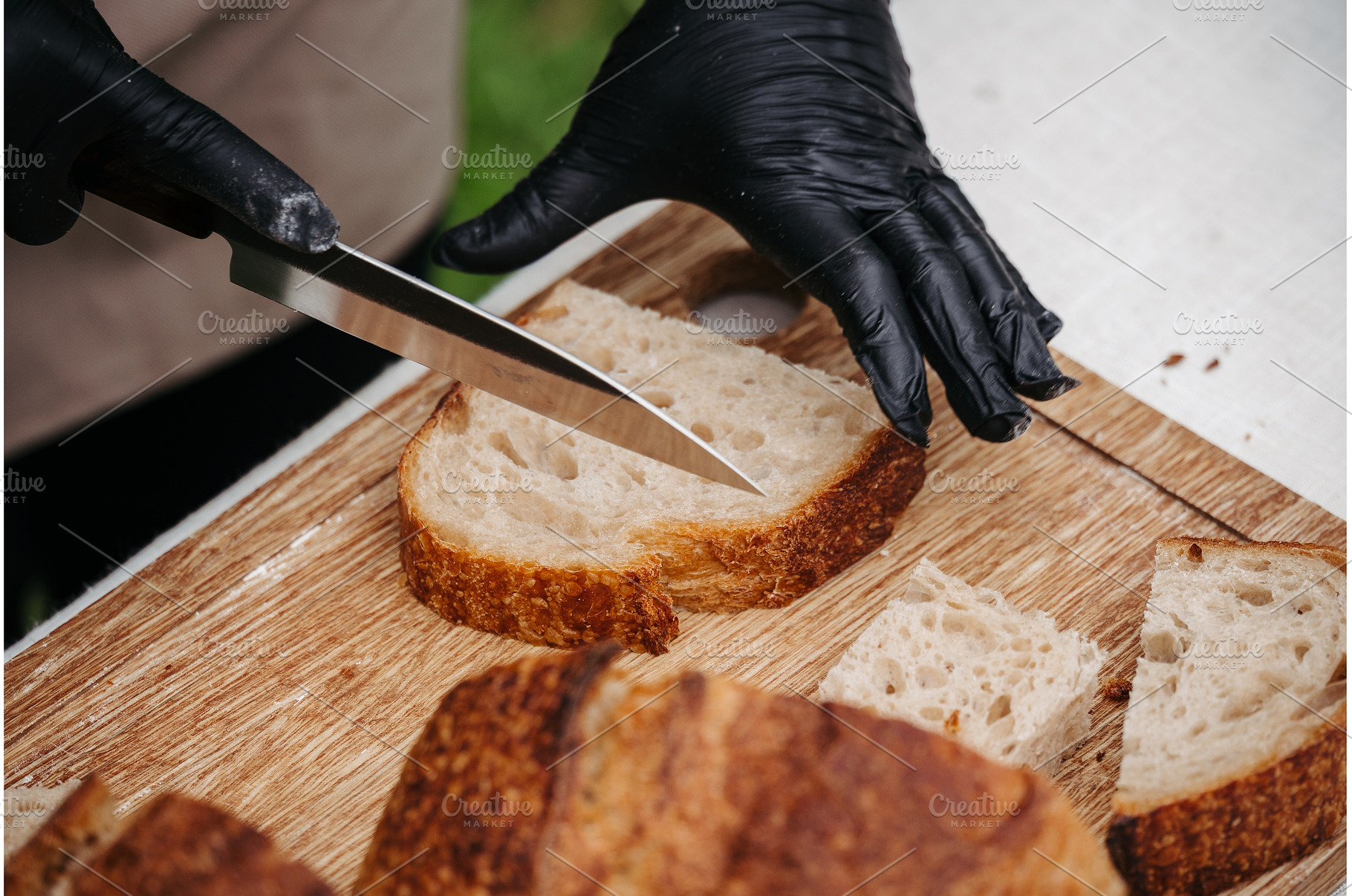 Cook cutting rustic sourdough bread, a Food & Drink Photo by HalfPoint