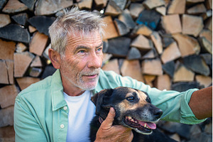 Older man with dog in front of, an Animal Photo by HalfPoint