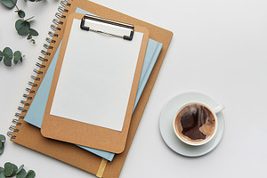 Clipboard with blank paper, notebooks and coffee cup on white ta, a Business Photo by Olena Rudo