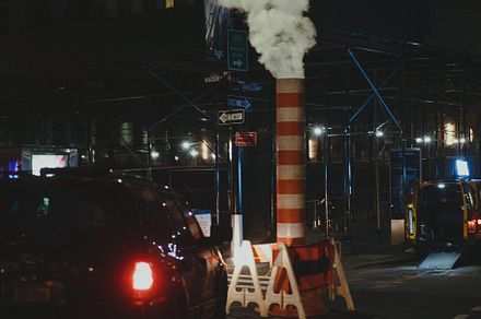 New York at night, steam from the striped pipe.