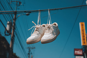 White sneakers hanging on wire, a Sports & Recreation Photo by Virgo Studio