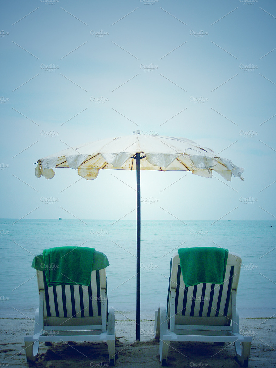 Two Plastic Deck Chairs On The Beach