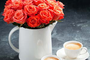 Two cups of espresso and a bouquet of roses