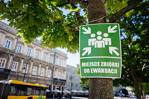 Evacuation assembly point sign attached to a tree in Warsaw, Poland, a Photo by AS photostudio