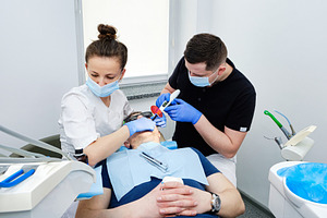Dental Curing Light: Polymerization Process. Dentist and assistant applying fil, a Health & Medical Photo by Rohan Photography