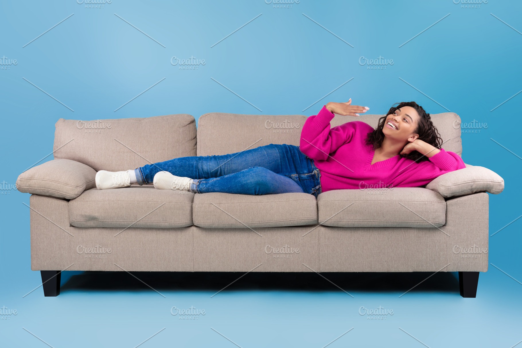 Happy young black woman lying on sofa, feeling hot, waving at herself, mockup f, a Photo by Prostock-Studio