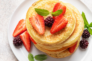 Stack of pancakes with fresh strawberries and blackberries, a Food & Drink Photo by Olena Rudo