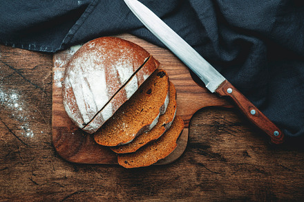 Rye sourdough bread with raisins, sliced pieces on wooden cuttin, a Food & Drink Photo by 5PH