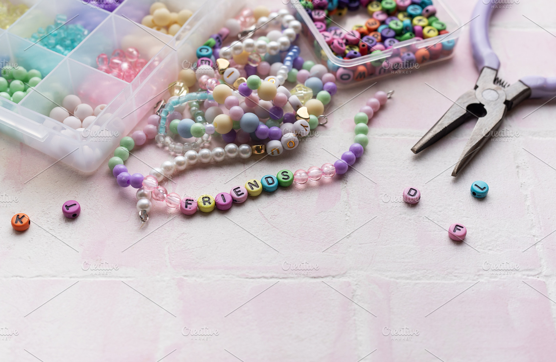 Colorful beads and pliers arranged on pink tile for jewelry maki, an Arts & Entertainment Photo by Olena Rudo
