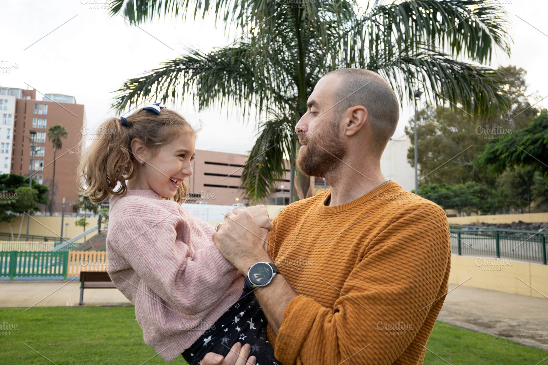 Father holding his daughter and sharing a happy moment at the park, a Person Photo by etorres69