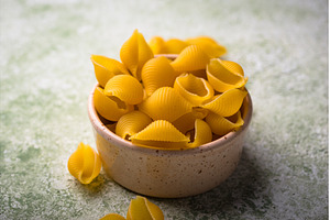 Raw pasta in shape of shells, a Food & Drink Photo by Yulia Furman