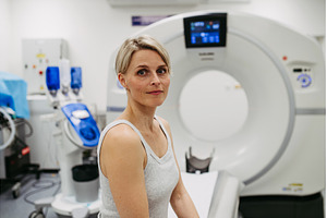 Woman sitting on CT scanner bed, a School & Education Photo by HalfPoint