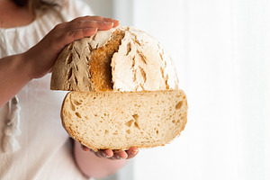 Sourdough bread hold in hands. No ye