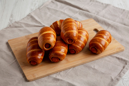 Homemade Sausage Buns on a bamboo board, side view., a Food & Drink Photo by LiudmylaChuhunova