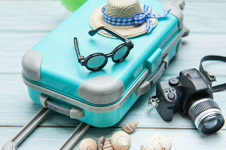Turquoise suitcase, sunglasses, straw hat, inflatable ring, came