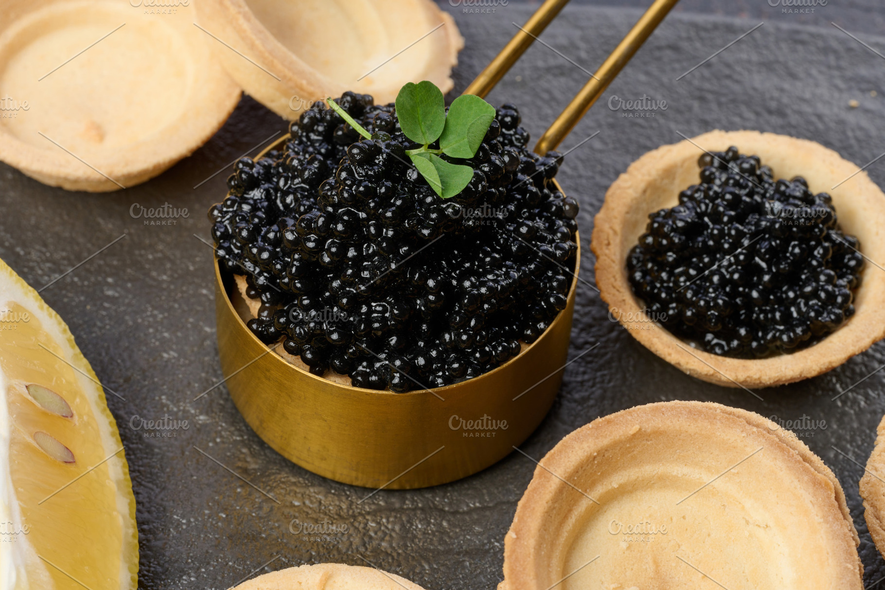 Black sturgeon caviar and empty round tartlets on table, top vie, a Food & Drink Photo by ndanko